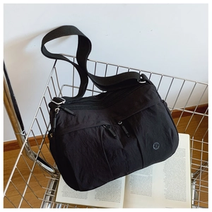 Detail of black waterproof nylon crossbody bag with multi-pockets and wide strap