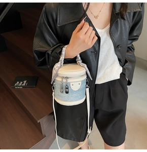 Détail du sac seau en denim avec poignée foulard à cœurs et breloques cadenas argent
