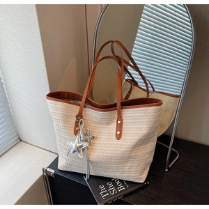 Detail der böhmischen Strohtasche mit braunen Ledergriffen und silbernem Sternanhänger
