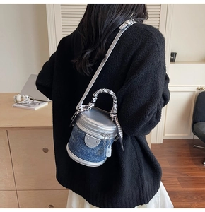 Gros plan du mini sac seau en denim bleu avec garniture en cuir argenté et foulard