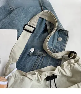Détail de la bandoulière réglable et de la fermeture par cordon du sac beige