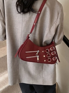 Burgundy pleated biker style crossbody bag with silver zippers and buckle straps