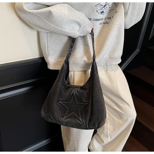 Detail of grey washed denim hobo bag featuring stitched star decor on a shoulder strap