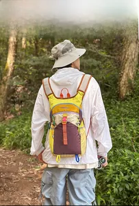Sac à dos extérieur multifonctionnel avec design coloré porté sur un sentier boisé