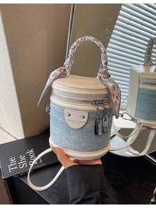 Petit sac seau en denim et cuir avec clous argentés et poignée enroulée d'un foulard
