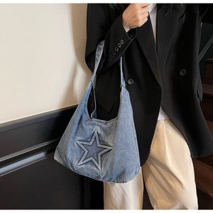 Detail of vintage blue denim tote bag featuring a large 3D star patch and textured fabric