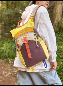 Détail d'un sac à dos de voyage multicolore avec des sangles orange réglables en extérieur