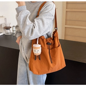 Détail du grand sac cabas en toile caramel avec cordon latéral et charm tasse à café