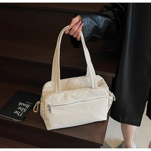 Detail view of large cream canvas tote with side drawstring and front zipper pocket