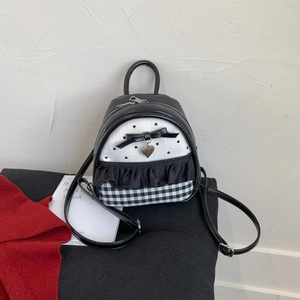 Detail of mini backpack with black and white heart prints, plaid patterns, and ruffled edges