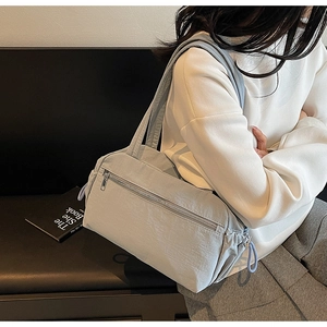 Detail view of light blue canvas tote bag featuring silver zipper and drawstring design
