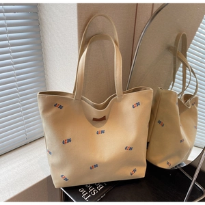 Detail view of large canvas tote bag with QZBG embroidery and premium leather accents