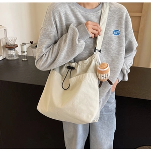 Gros plan du sac en toile blanc cassé avec cordon de serrage et charmant pendentif peluche