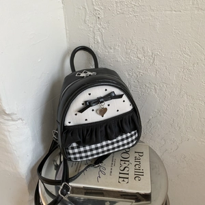 Detailed view of mini backpack featuring heart prints, bows, ruffles and checkered patterns