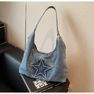 Detail of blue denim hobo bag featuring a 3D star embossing on the front surface