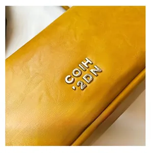 Détail du sac en cuir jaune grainé avec logo métallique argenté COIH 2DN chic