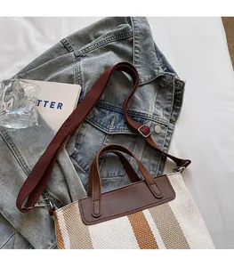 Detail of adjustable shoulder strap and canvas bucket bag styled on denim jacket