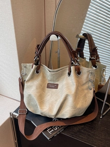 Minimalist beige large capacity tote bag with brown straps and silver hardware