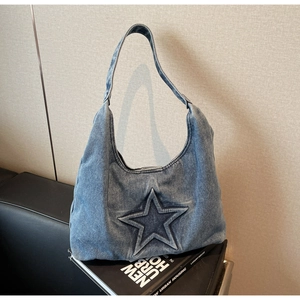 Detail of blue wash denim hobo bag featuring a 3D embossed star and Y2K vintage texture