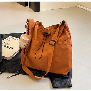 Détail du sac cabas orange à cordon avec sangle réglable et breloque en peluche