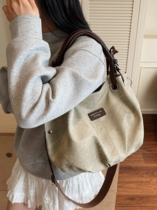 Olive green large capacity leather tote bag with brown straps in a lifestyle setting