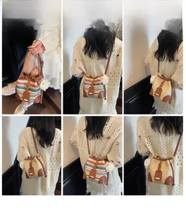 Detail of hand-woven straw bucket bag with leather accents and sheep pendant