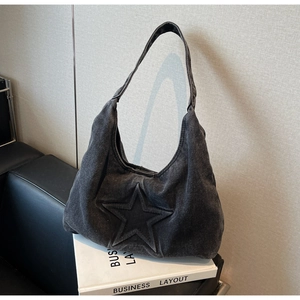 Close-up of washed denim hobo bag featuring a retro star embossed pattern on grey fabric