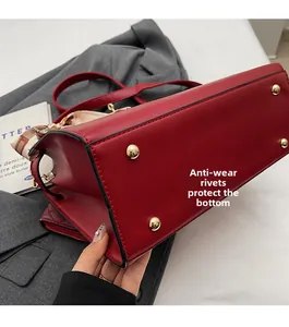 Detail of red wedding handbag base featuring protective gold-tone metal bottom rivets