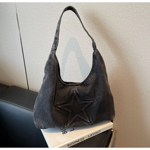 Detail of grey washed denim hobo bag featuring embossed stars and vintage texture