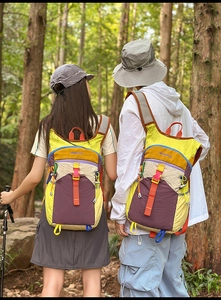 Détail d'un sac à dos extérieur coloré avec sangles renforcées et boucles multicolores en forêt