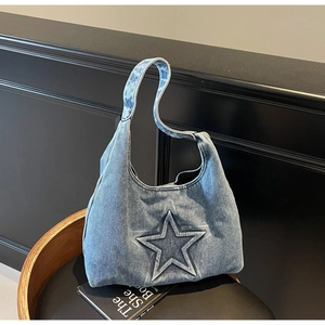 Close-up of vintage blue denim hobo bag featuring embossed star design and wash texture