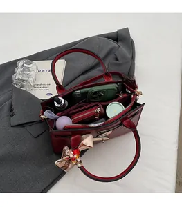 Detail view of burgundy handbag interior showing large capacity with multiple compartments