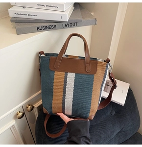 Detail of color-block knitted tote bag showing blue and brown striped fabric texture