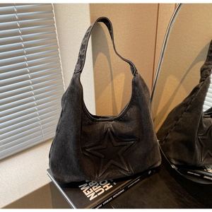 Detail shot of black washed denim tote bag featuring a 3D star pattern and urban style
