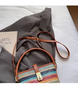 Close-up of adjustable brown leather strap and colorful woven texture bucket bag