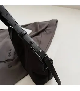 Detail of adjustable nylon shoulder strap with metal eyelets and silver buckle