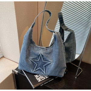 Detail of blue denim tote bag featuring a star patchwork design and textured wash finish