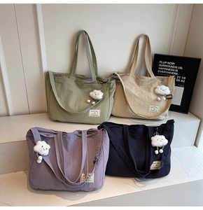 Détail de grands sacs fourre-tout en toile en quatre couleurs avec breloque nuage et sangle