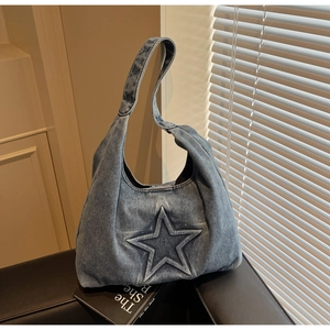Close-up of embossed star pattern on blue washed denim tote bag with soft texture