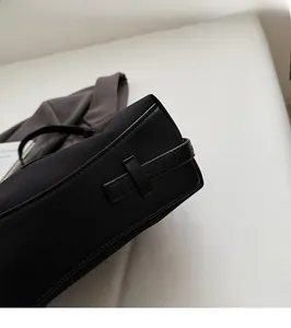 Detailed close-up showing reinforced stitching and premium black leather trim on canvas bag
