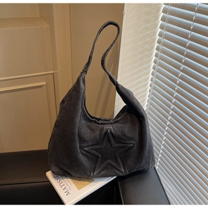 Macro view of washed dark grey denim tote bag featuring embossed five-point star details