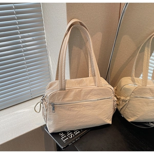 Detail of cream canvas tote bag with multi-pocket design under artistic window shadows
