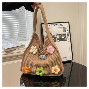 Detail of hand-crocheted 3D flowers on a beige knitted tote bag with fine texture