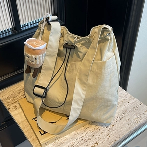 Sac fourre-tout beige en nylon avec cordon, pendentif peluche et large bandoulière