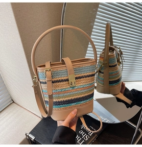 Detailed mirror view of a colorful woven bucket bag with beige leather strap and buckle