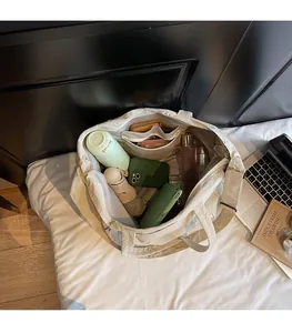 Intérieur spacieux du grand sac fourre-tout en toile beige montrant des poches de rangement