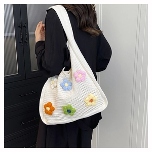 Detailed shot of 3D knit floral patterns on a large white summer crochet tote bag