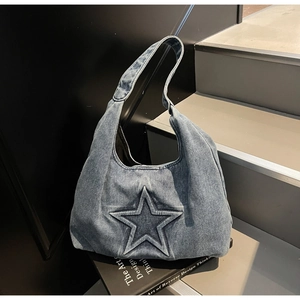 Detailed view of blue denim tote bag with a central 3D star pattern and a wide strap