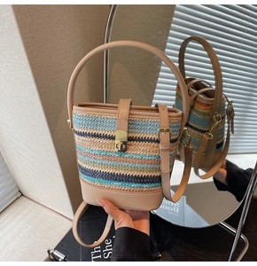 Detailed macro view of multi-color striped woven bucket bag with elegant gold twist lock