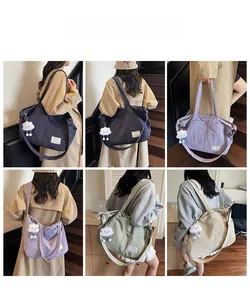 Détail du sac cabas en toile multicolore avec bandoulières et accessoire nuage peluche
